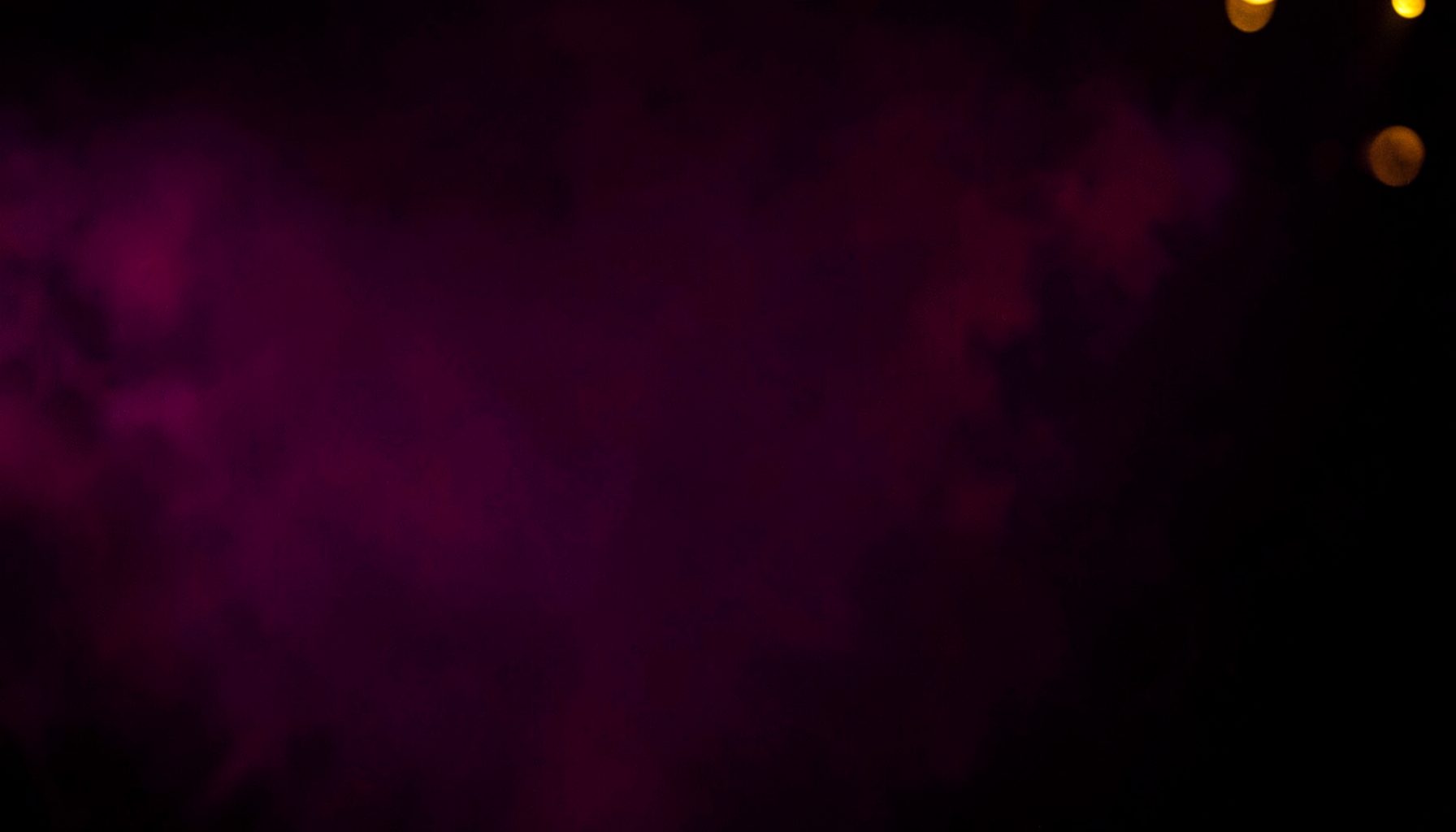 Deep magenta and purple atmospheric glow over a dark backdrop, with warm golden highlights suggesting an intimate, moody adult entertainment ambiance